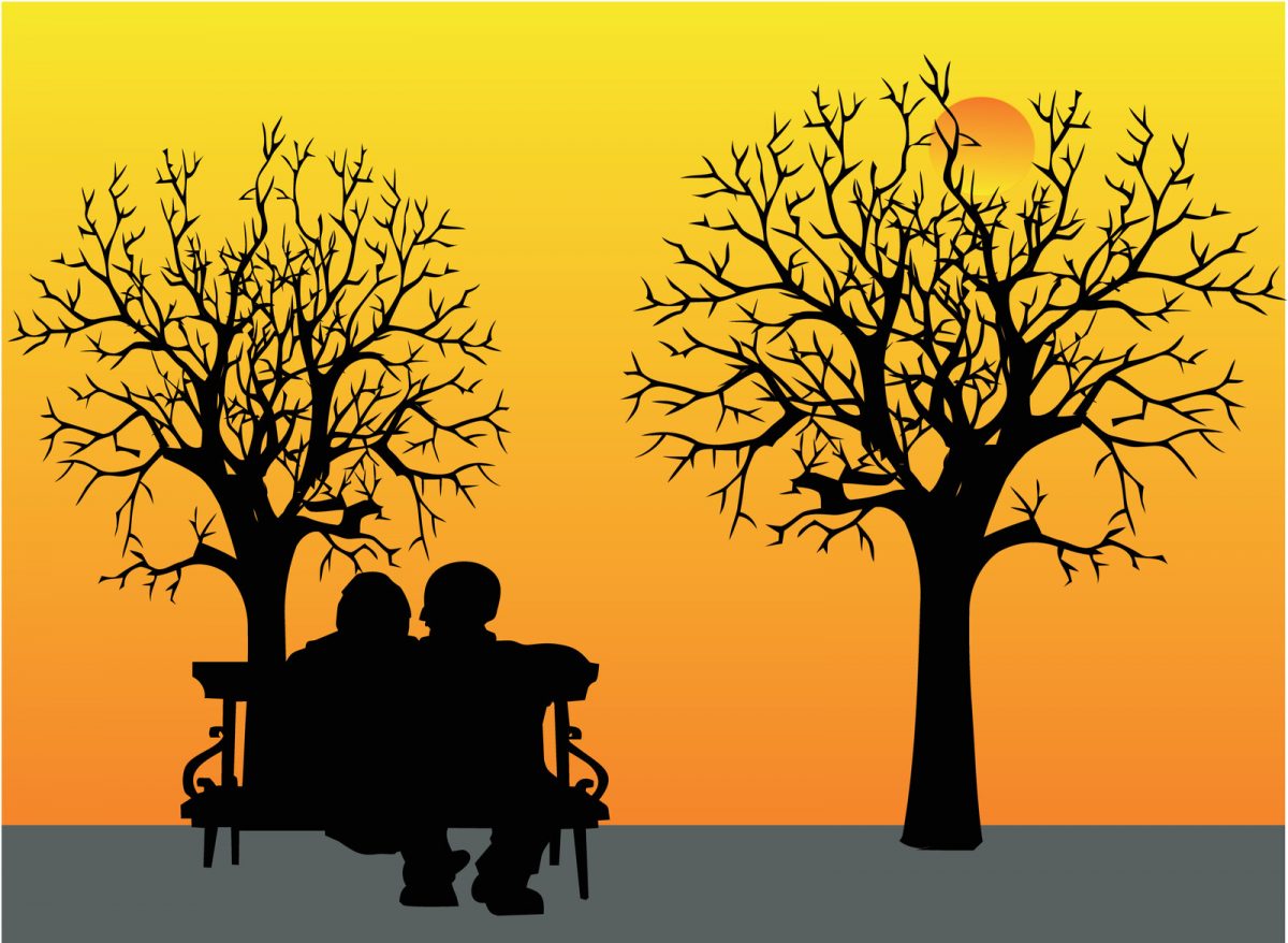 Sillouhette of two people on bench under trees