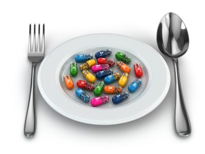 a dinner plate with a variety of colorful capsules with a fork and spoon on the table