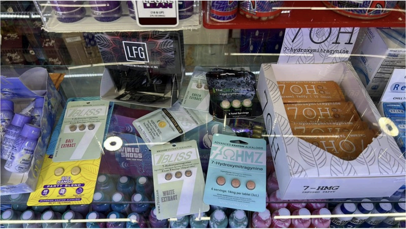 Kratom-related products behind a convenience store glass counter. Products include 7-hydroxymitragynine tablets and caramel taffy.