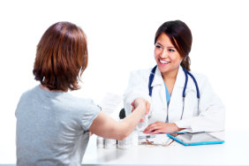 smiling pharmacist is shaking hands with a patient across a table